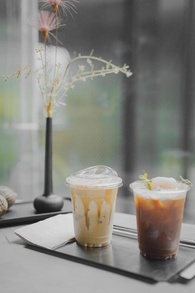 Close up glass of ice black coffee with lychee juice and ice cappucino on raw cement table of a coffee shop summer terrace, menu photography. photo