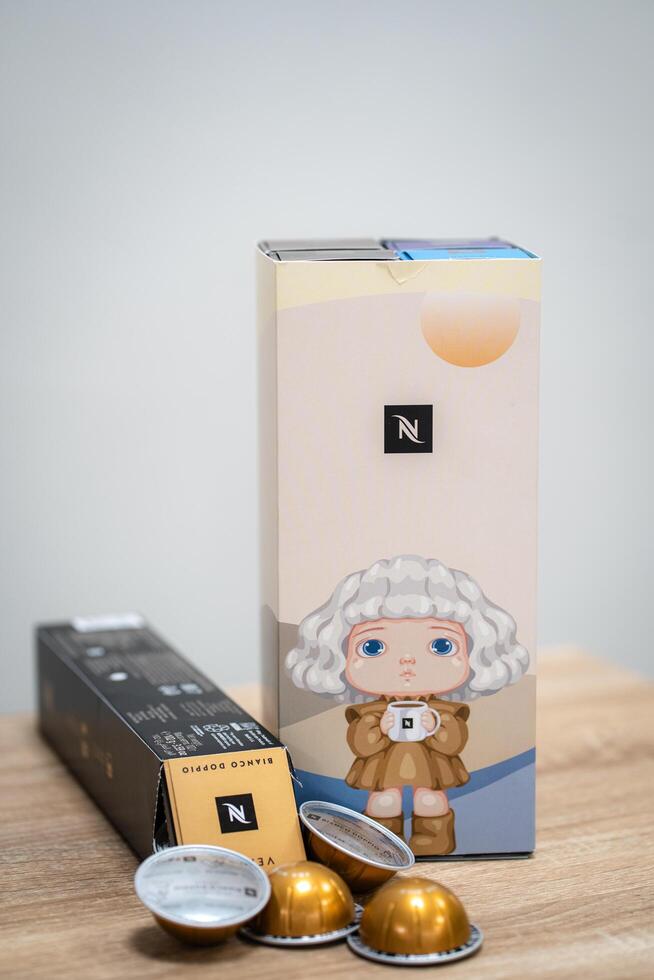 PATHUM THANI, THAILAND, August 29 2024 - Editorial image of Nespresso VERTUO 9 years anniversary Boxes and Coffee Capsules on Wooden table photo