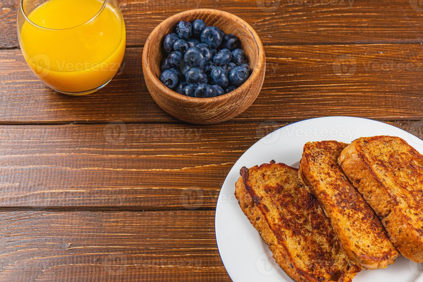 French toast on a white plate with blueberries and orange juice for breakfast photo