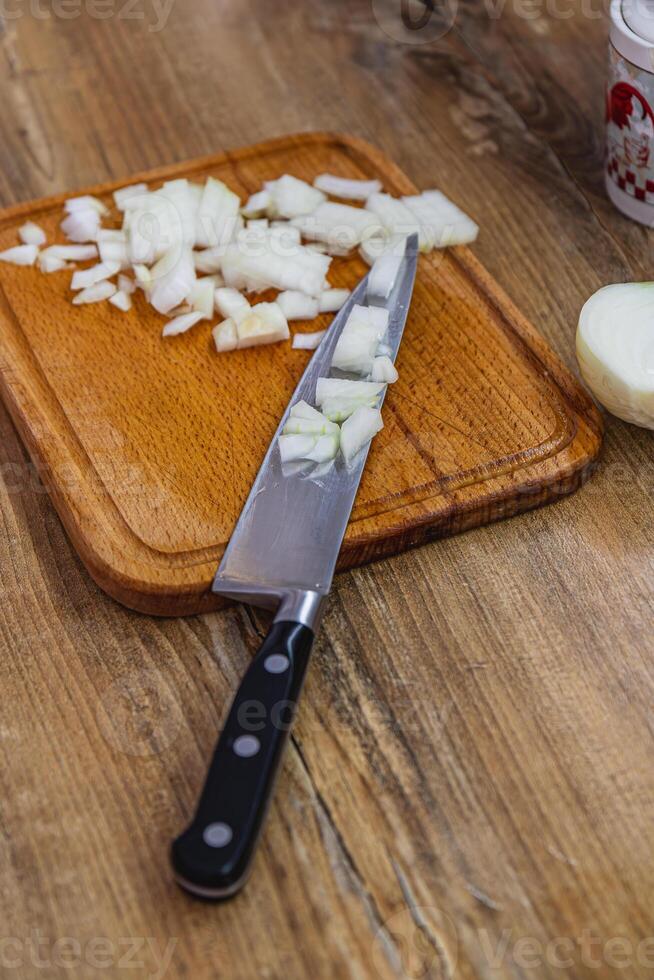Finely chopped onion, half an onion and a knife on the side photo