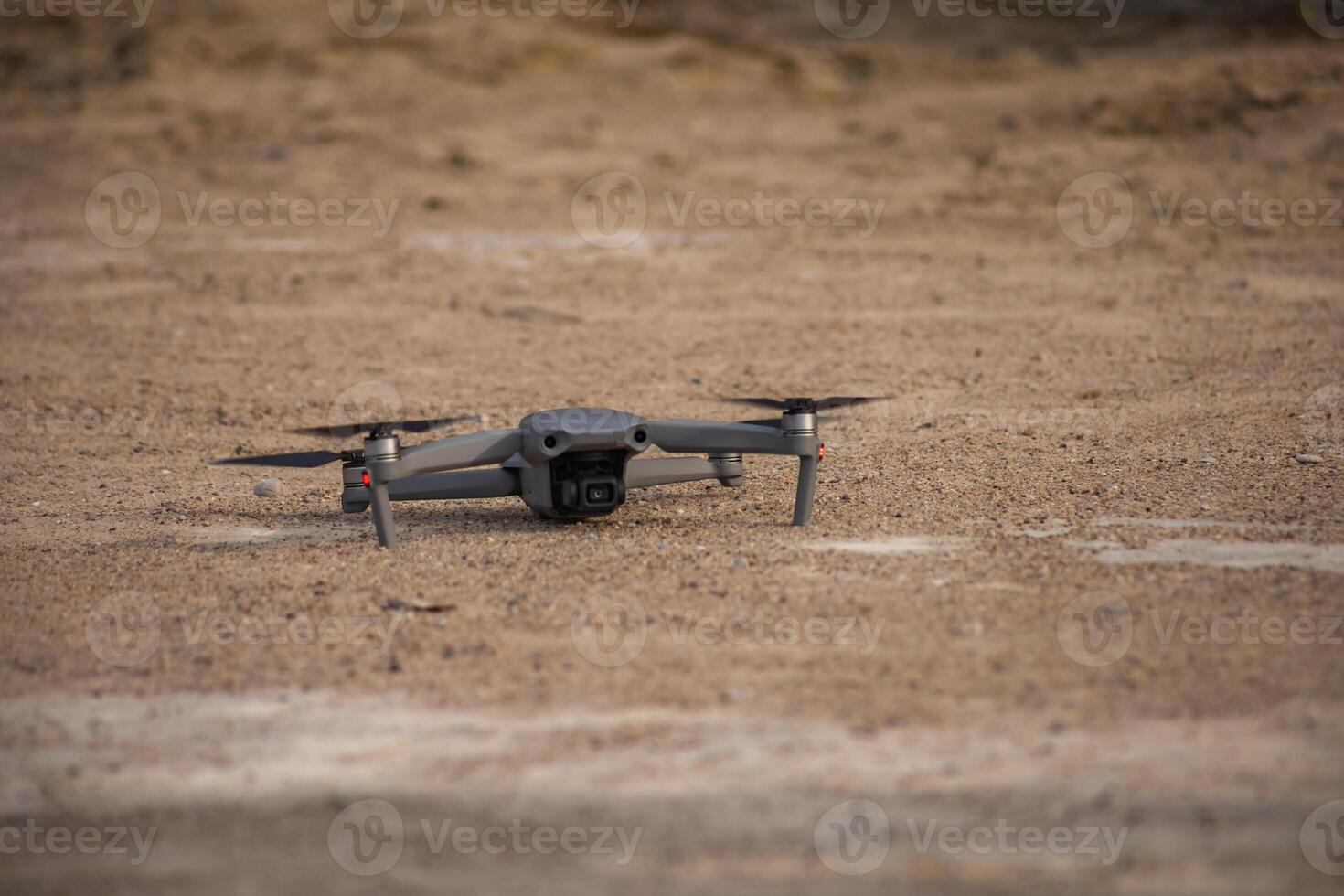 a gray drone standing on the ground ready to launch photo