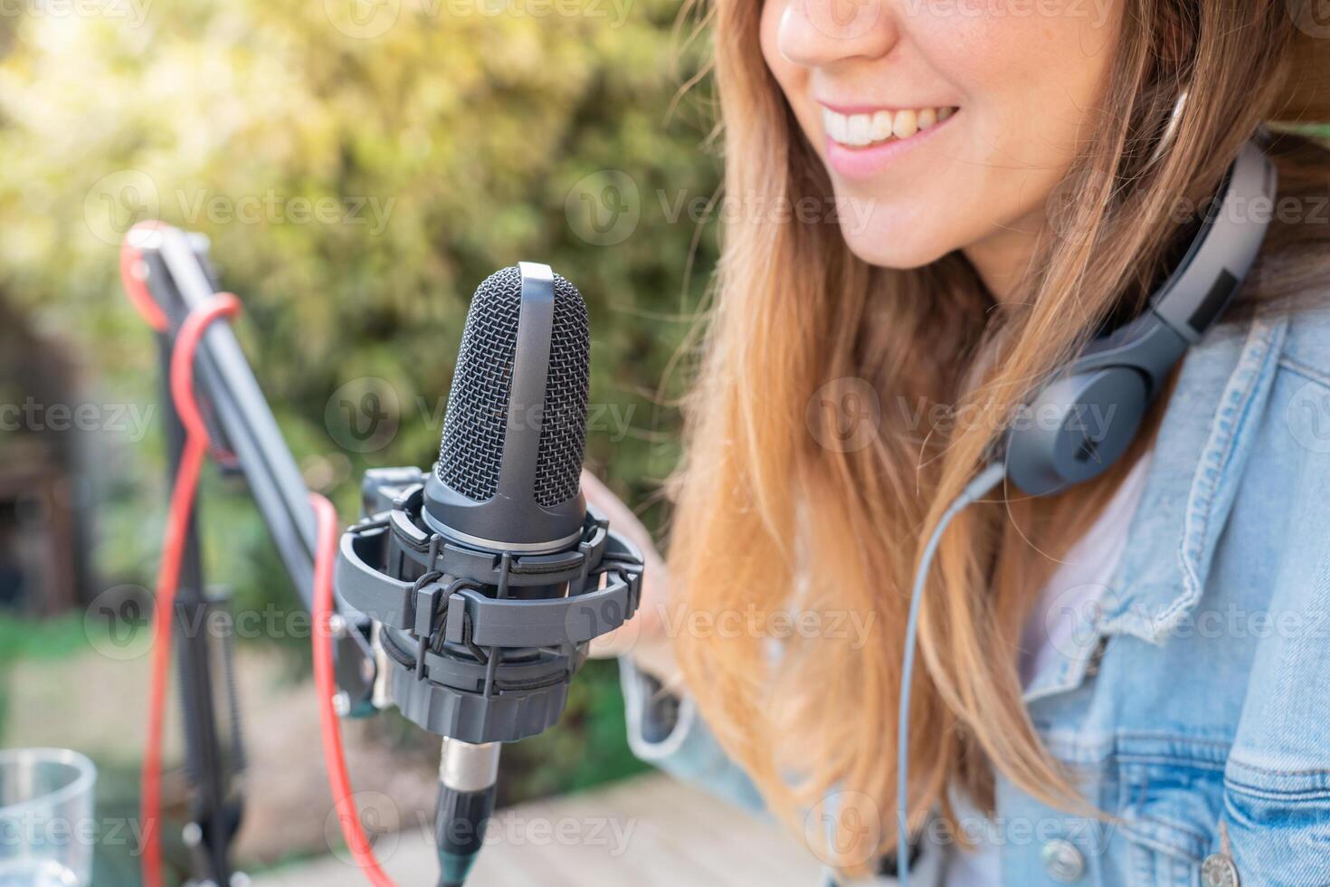 Closeup of a woman recording radio podcast talking during live stream session outdoor photo