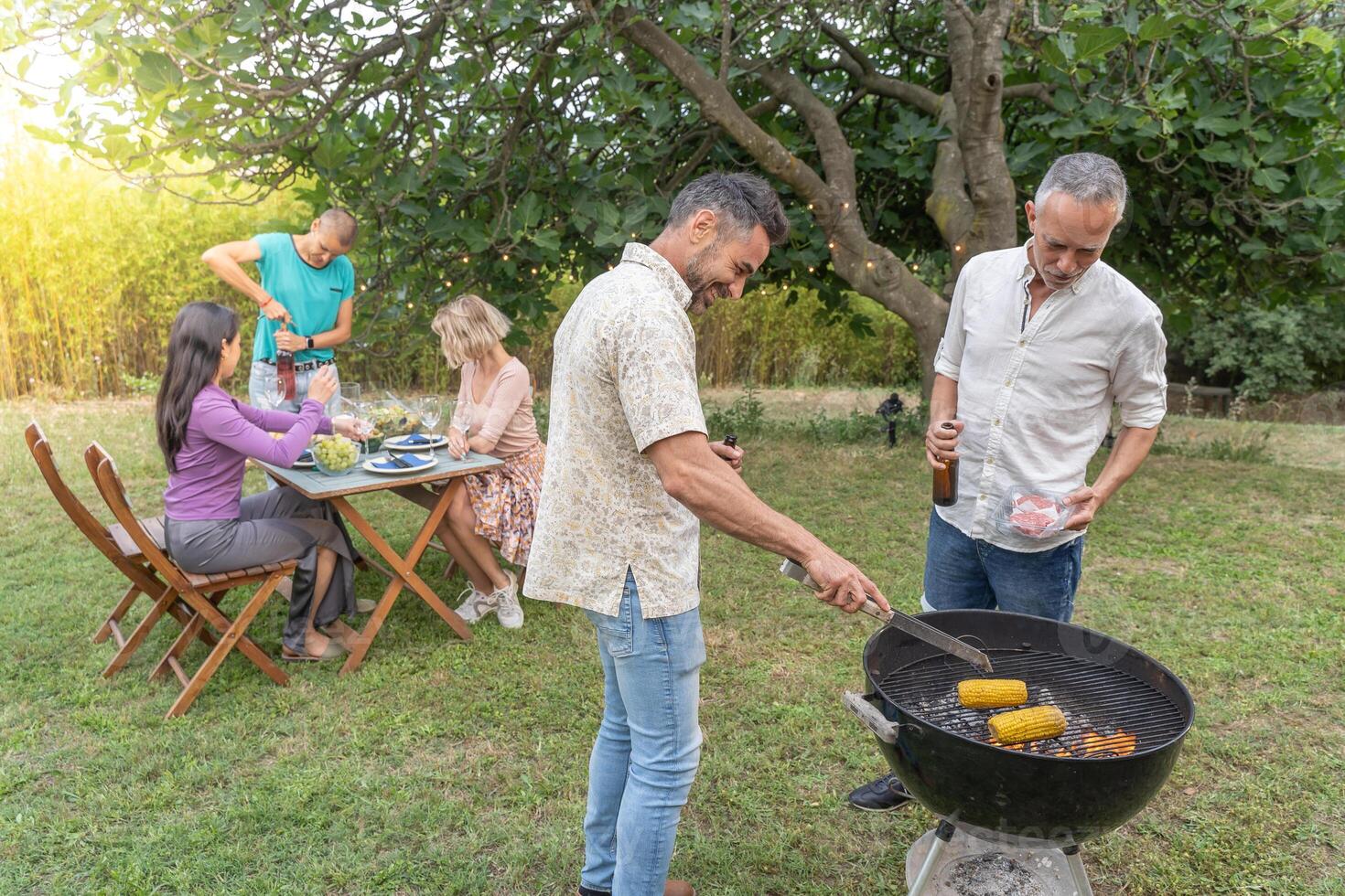 Family around the barbecue together. photo