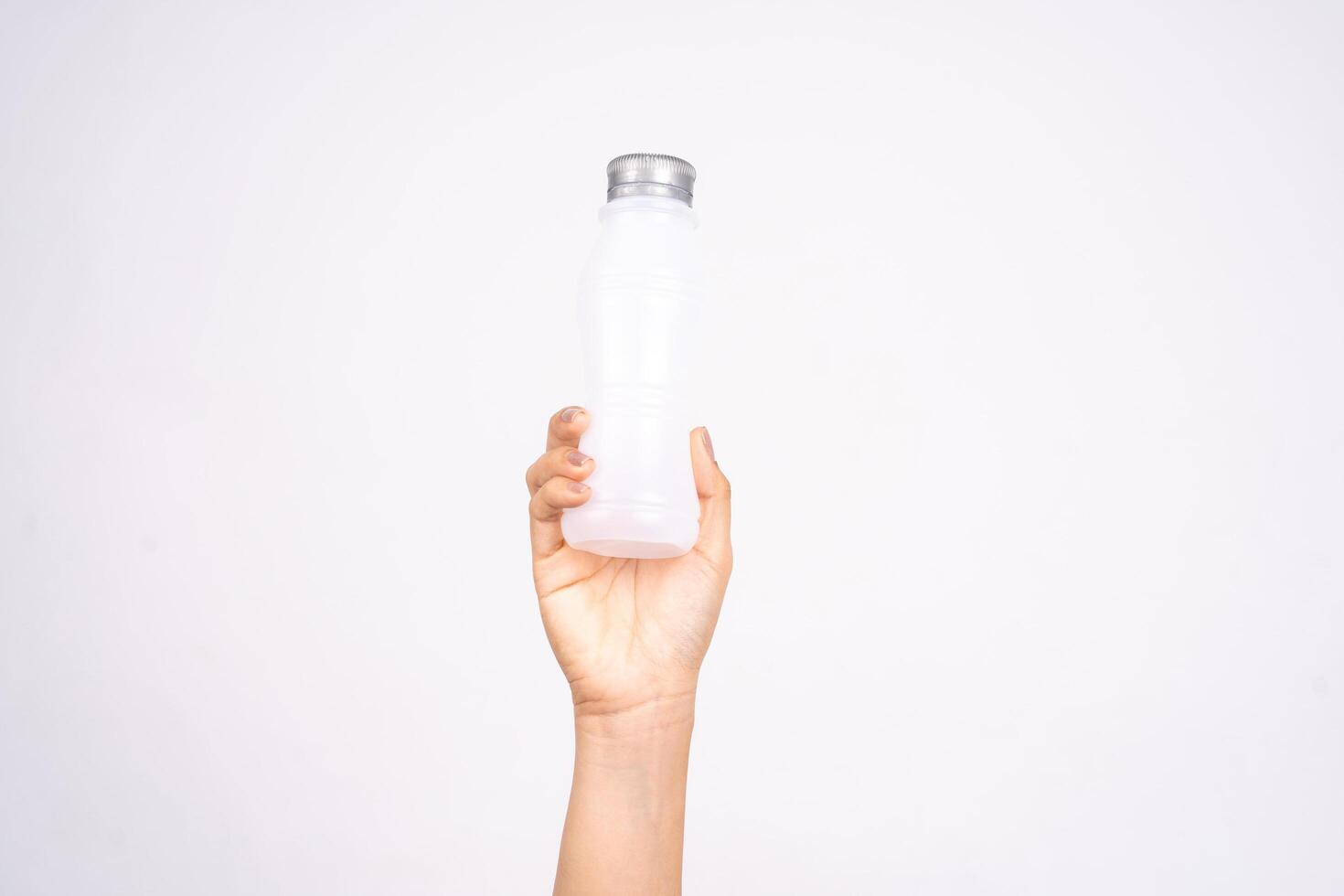 Photo of female hand holding white plastic bottle isolated on white background. Recycling concept.