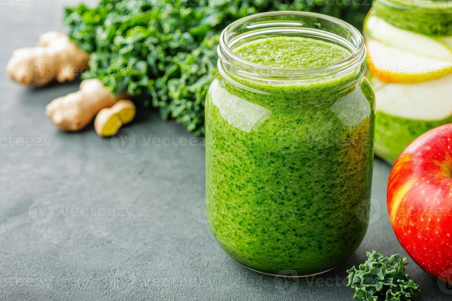 Fresh green smoothie in a jar with apples and ginger on a dark surface. photo