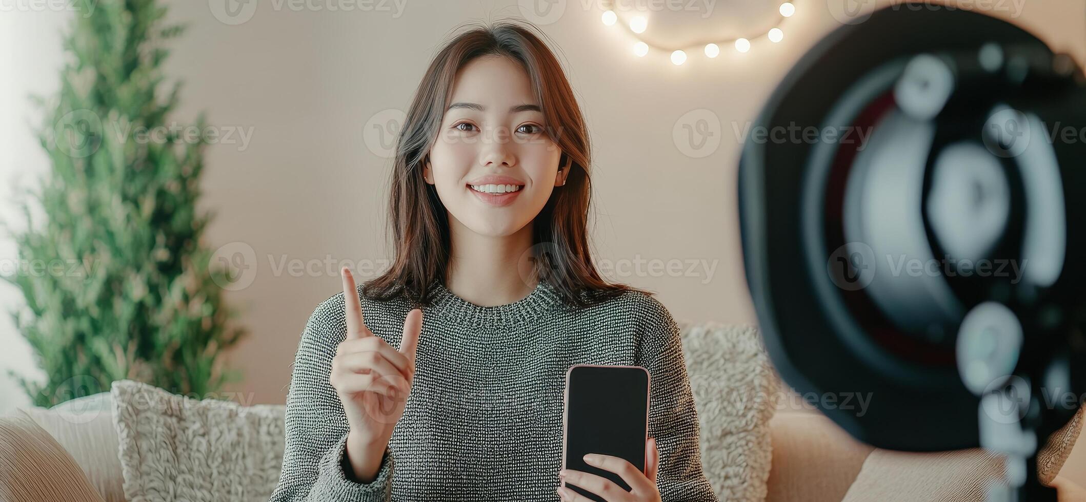 Smiling woman recording content at home with smartphone and soft lighting. photo