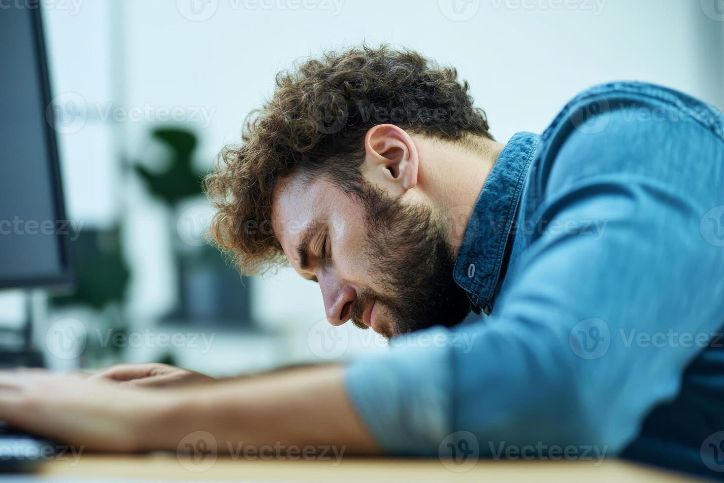 Exhausted man resting his head on a desk at work. photo