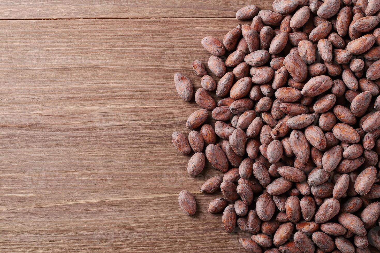 Cocoa beans scattered on a wooden surface, natural texture and rich colors. photo