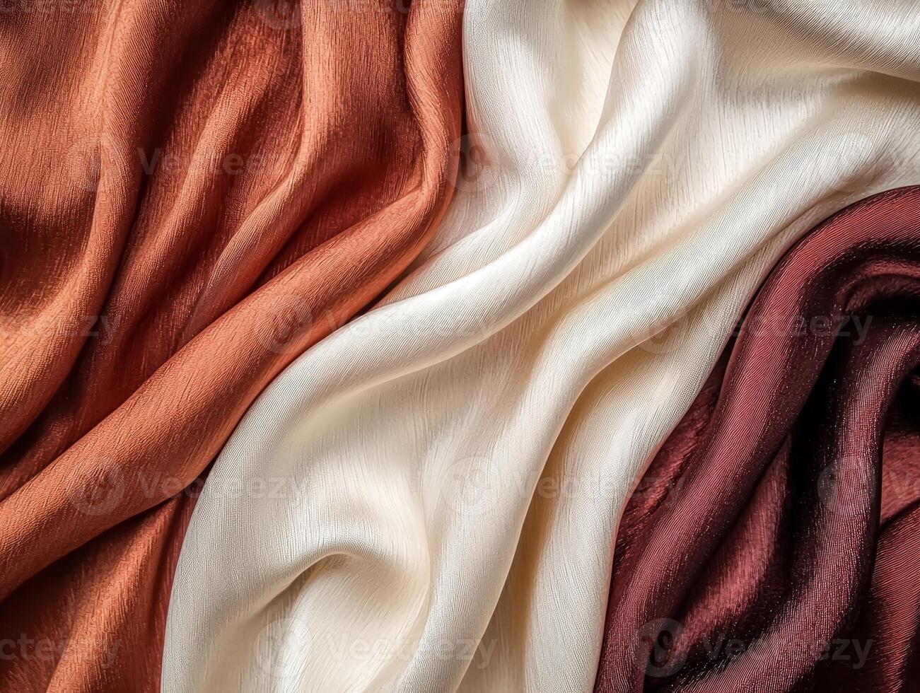 Soft, flowing silk fabric in warm colors, elegant draping on a smooth surface. photo