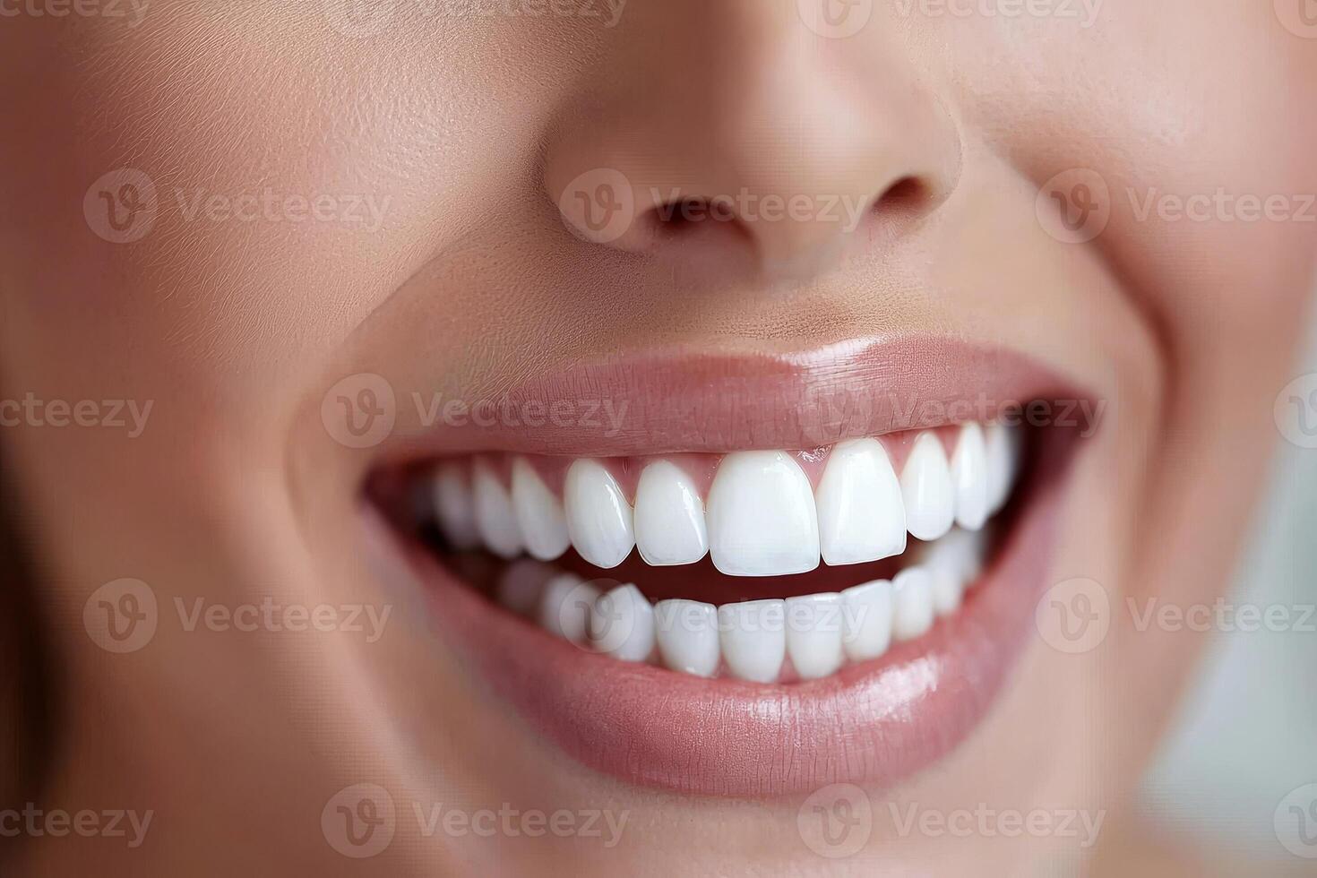 Close-up of a woman smiling with perfect white teeth on a neutral background. photo