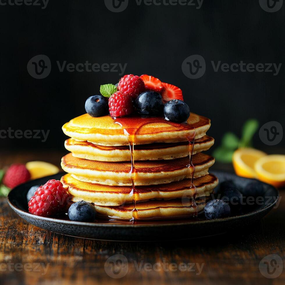Delicious stack of pancakes topped with fresh berries and syrup on dark background. photo