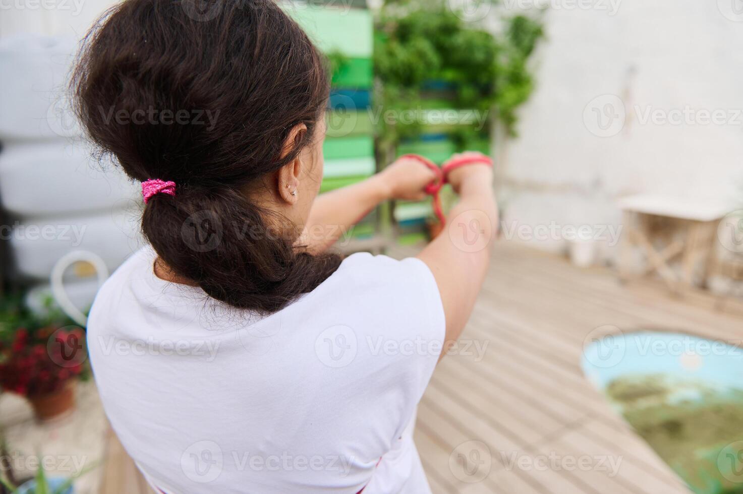 Woman using a resistance band in outdoor exercise setting emphasizing healthy lifestyle and fitness motivation photo
