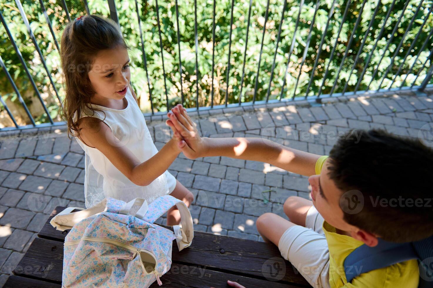 Children giving high five outdoors in a playful moment photo