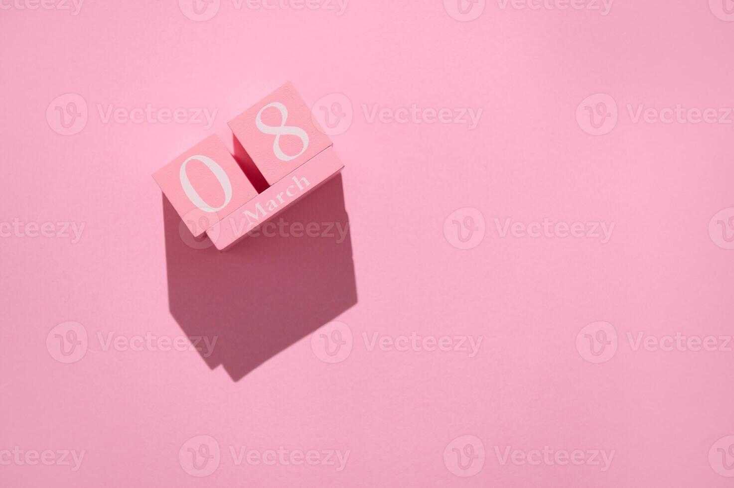 Pink wooden calendar block displaying March 8 on a pink background, symbolizing International Women's Day celebration photo