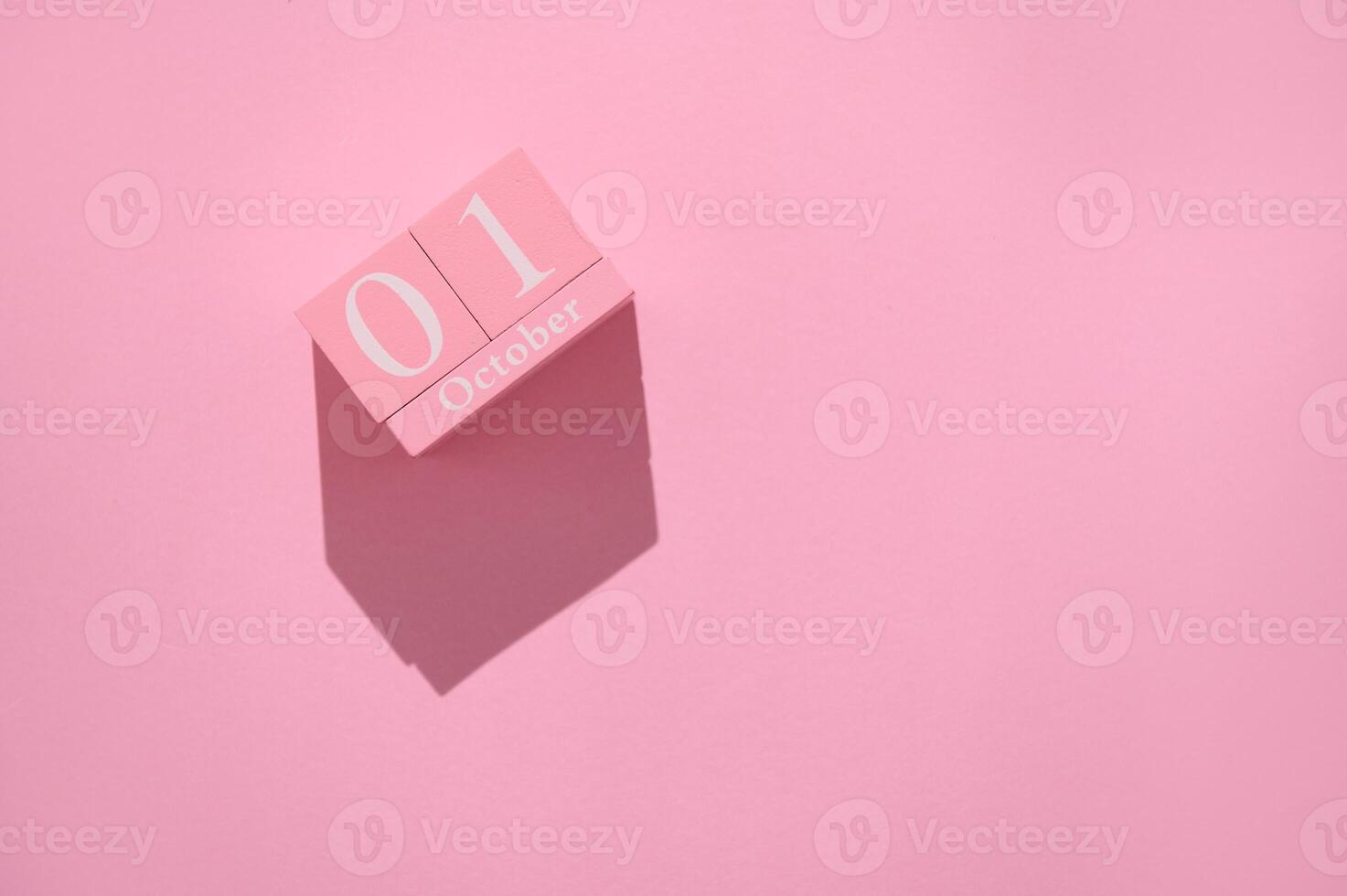 Pink calendar block displaying October 1 on a soft pink background with a shadow, symbolizing the arrival of a new month in vibrant style. photo