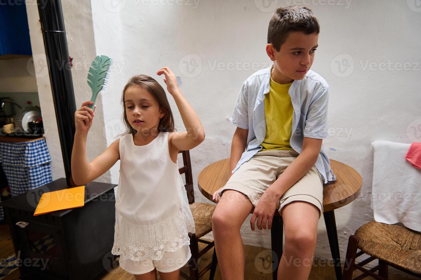 Children playing indoors with feather and table setting photo