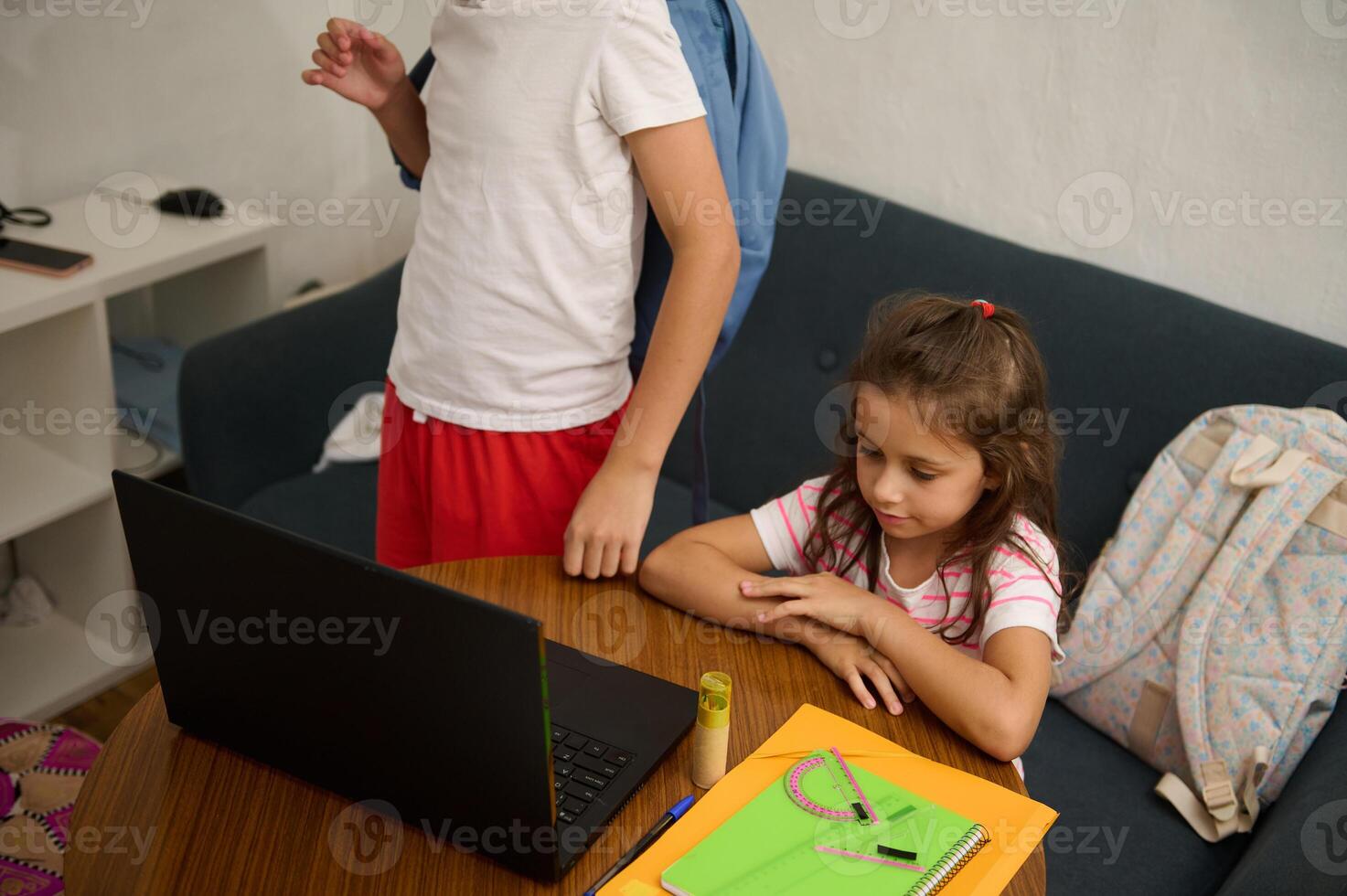 Children engaging in online learning at home with laptop photo