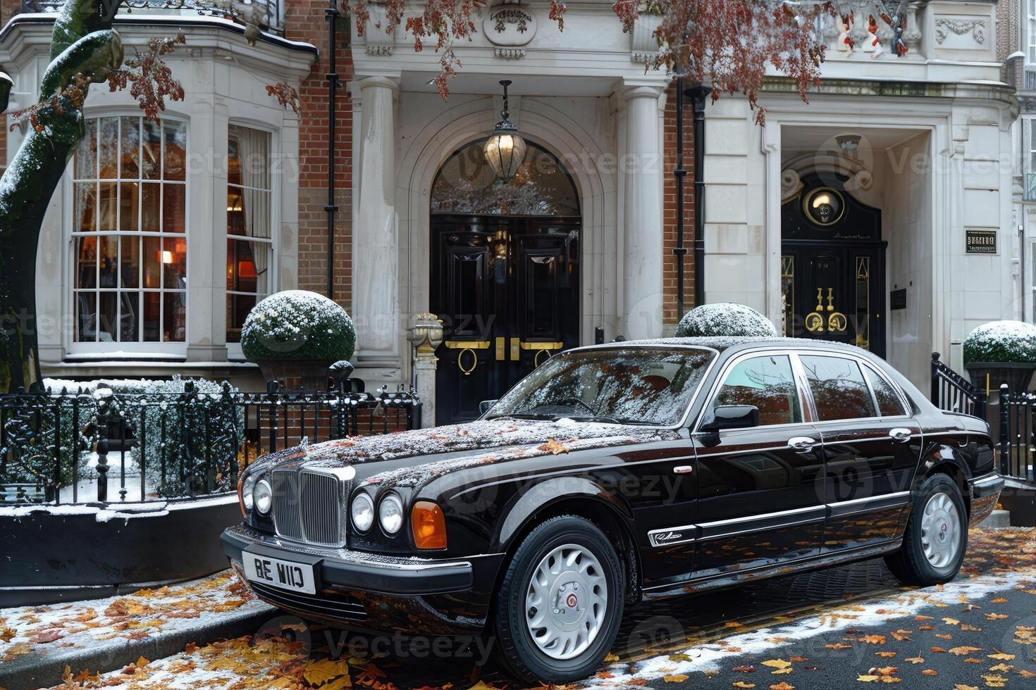 Black Luxury Sedan Parked in Front of a London Townhouse photo
