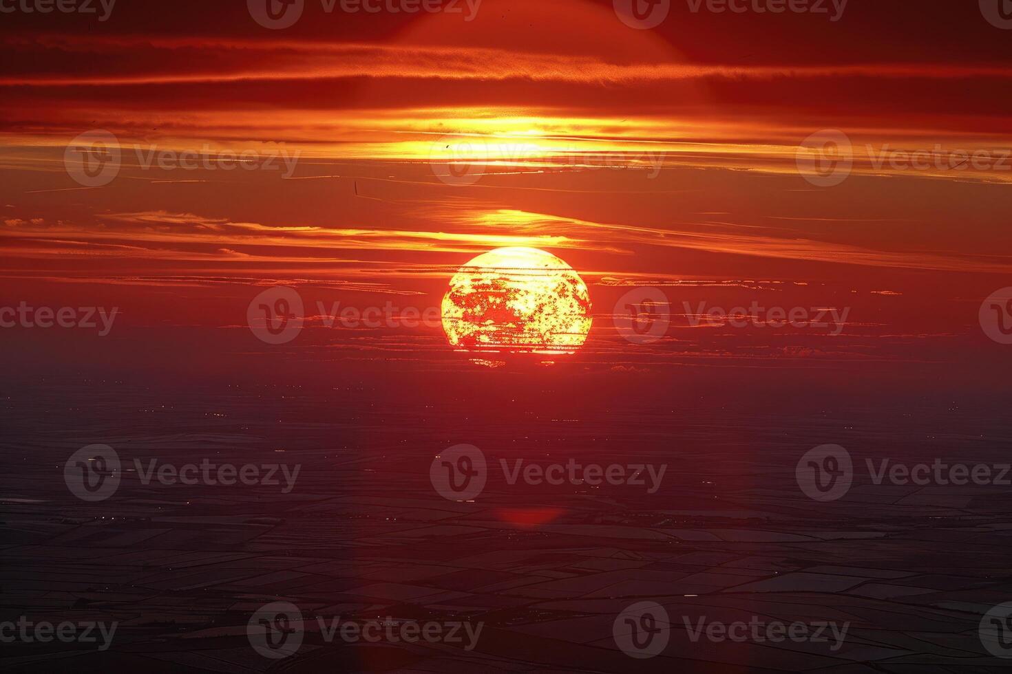 The sun is setting over a field photo
