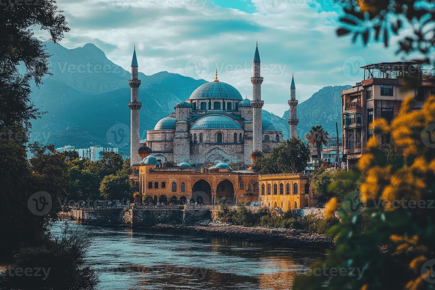 A Mosque in a City by a River with Mountains in the Background photo