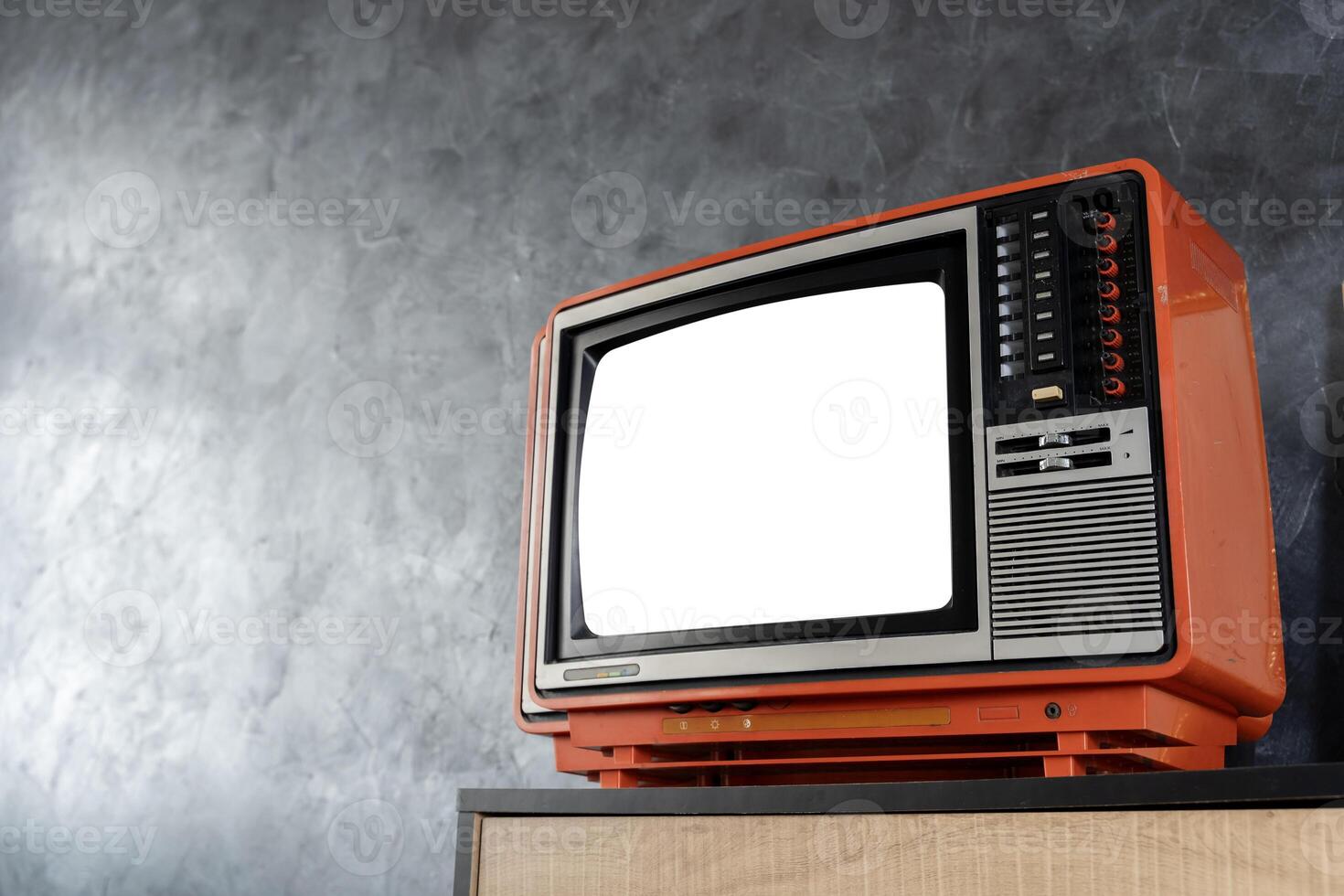 A retro television with a blank screen sits in a room. An old, orange television set is turned off, clipping path. photo