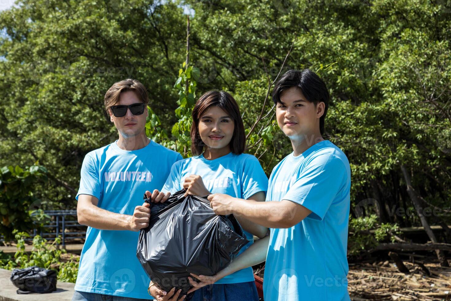 A team of young and diversity volunteer worker group enjoy charitable social work outdoor in cleaning up garbage project at the mangrove forest photo