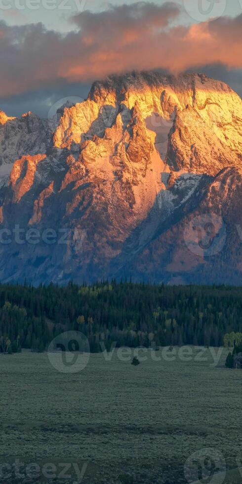 The sun sets over the mountains in the background photo