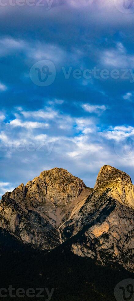 A mountain with clouds in the sky photo