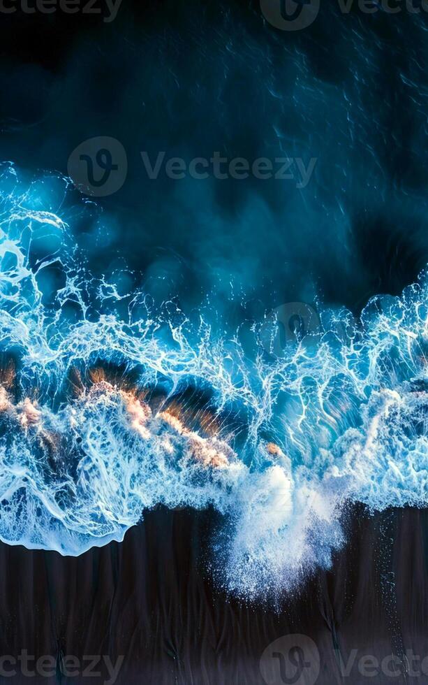 An aerial view of a wave crashing into the ocean photo