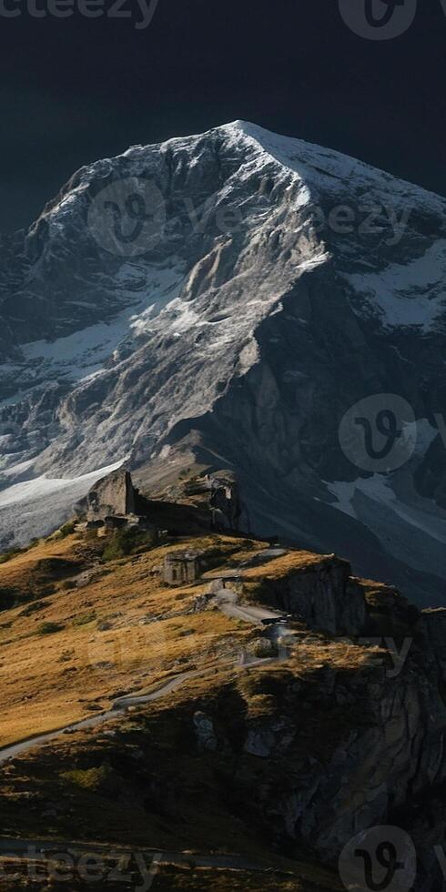 A mountain with snow capped peaks and clouds photo