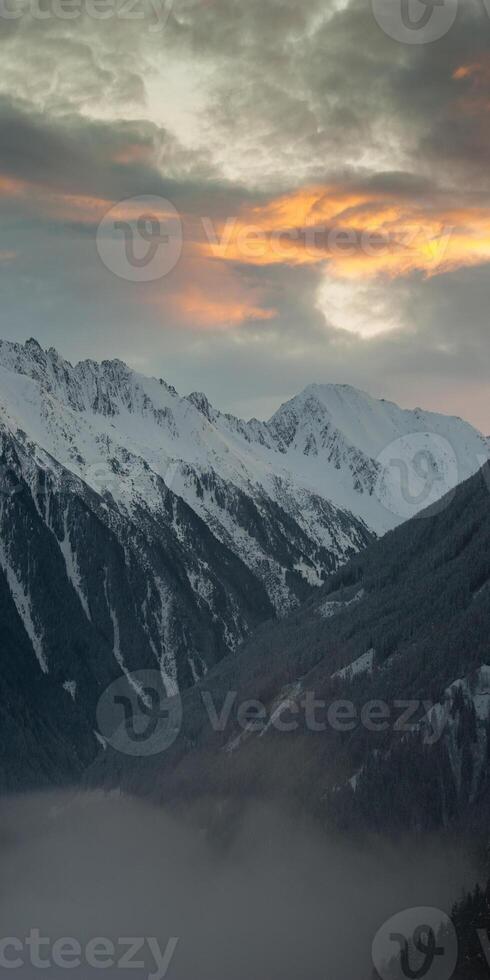 A snowy mountain range with a foggy sky photo