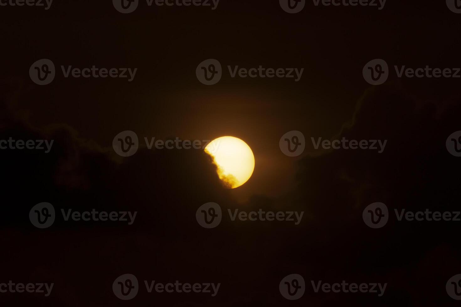 Big sun on dark sunset sky with dark clouds. photo