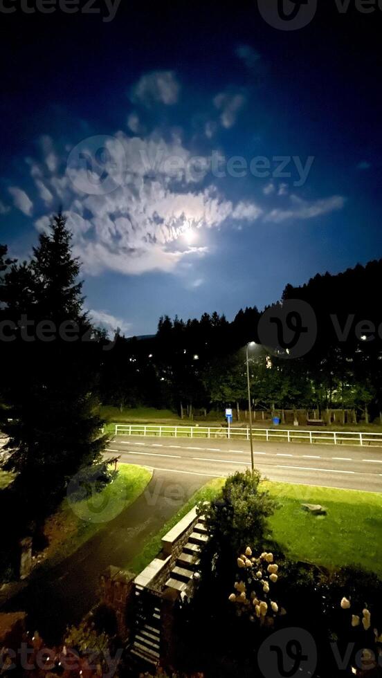 Night landscape, full moon behind clouds in the sky photo