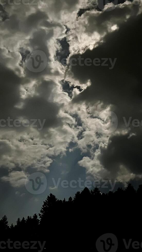 Night landscape, full moon behind clouds in the sky photo