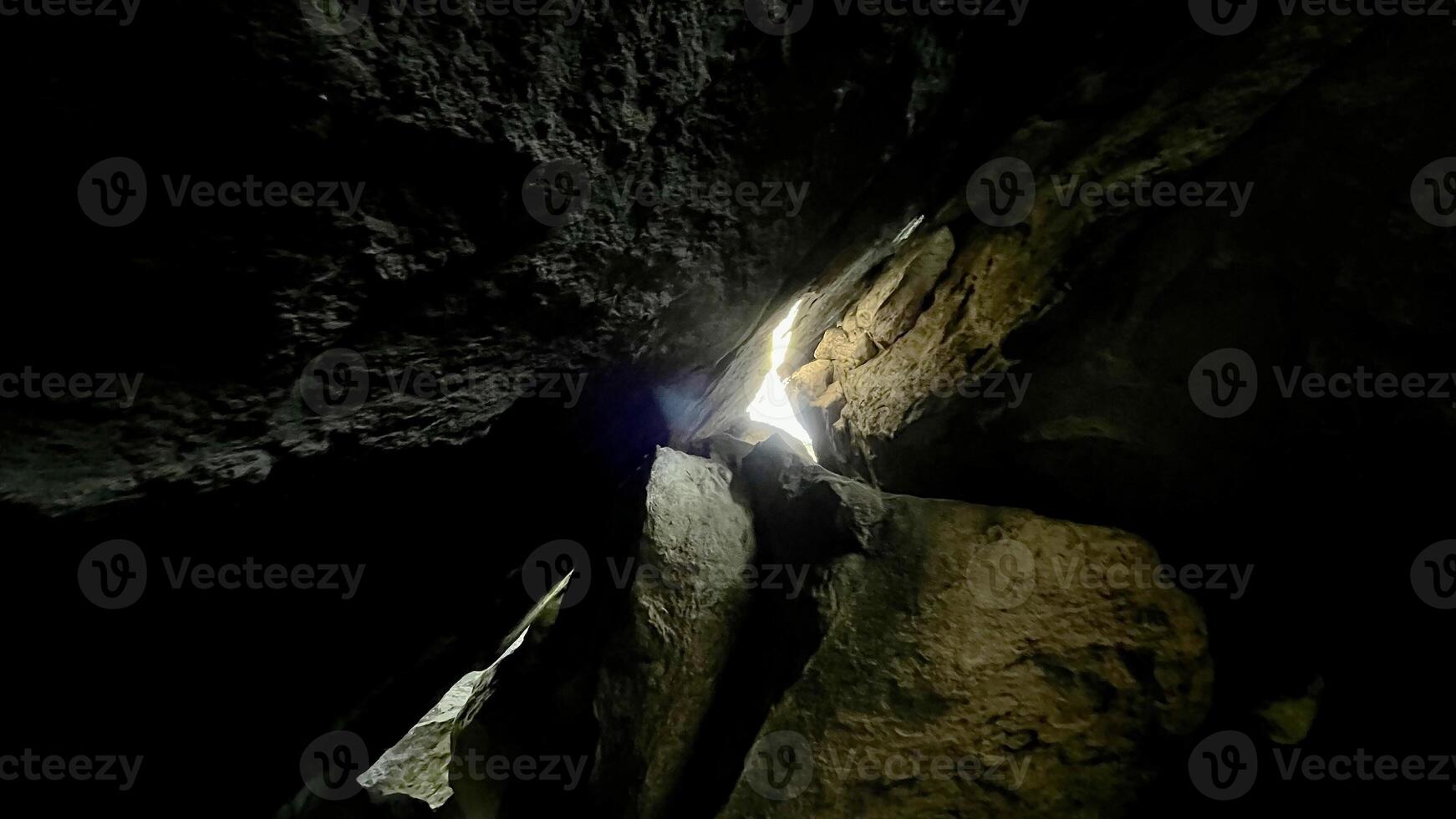 Sun rays pass through the stones in a cave. Poland photo