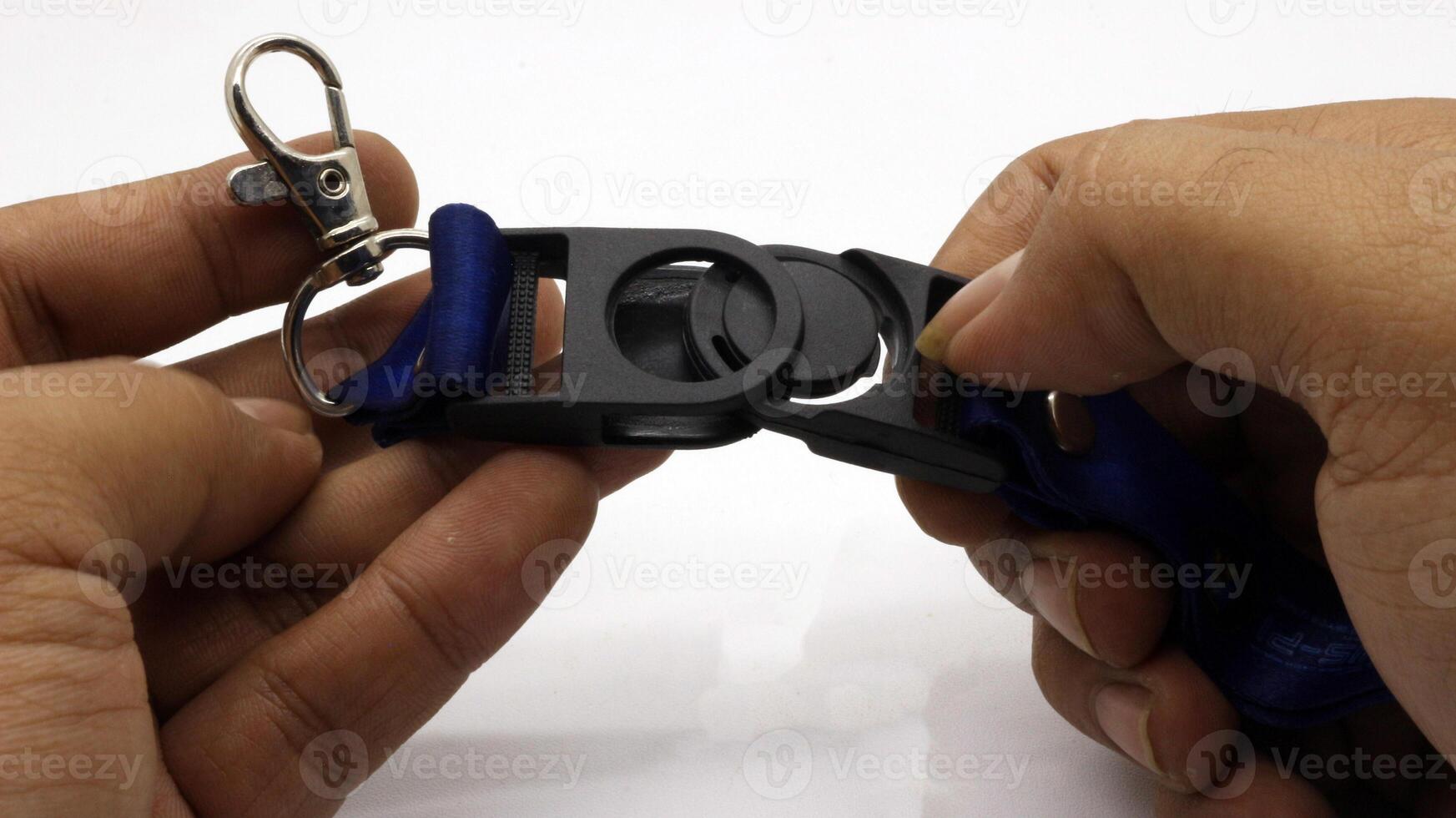 The neck lanyard is held by an adult's hand photo