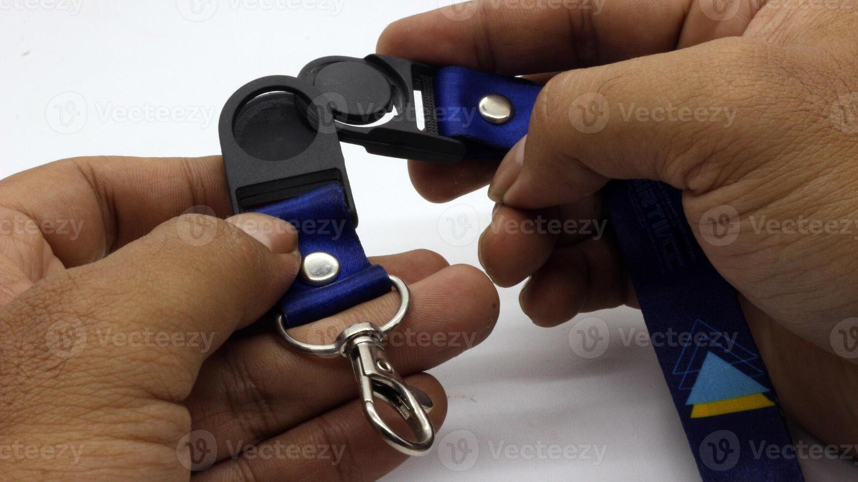 The neck lanyard is held by an adult's hand photo