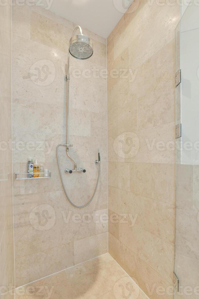 A shower with a shower head and a stand photo