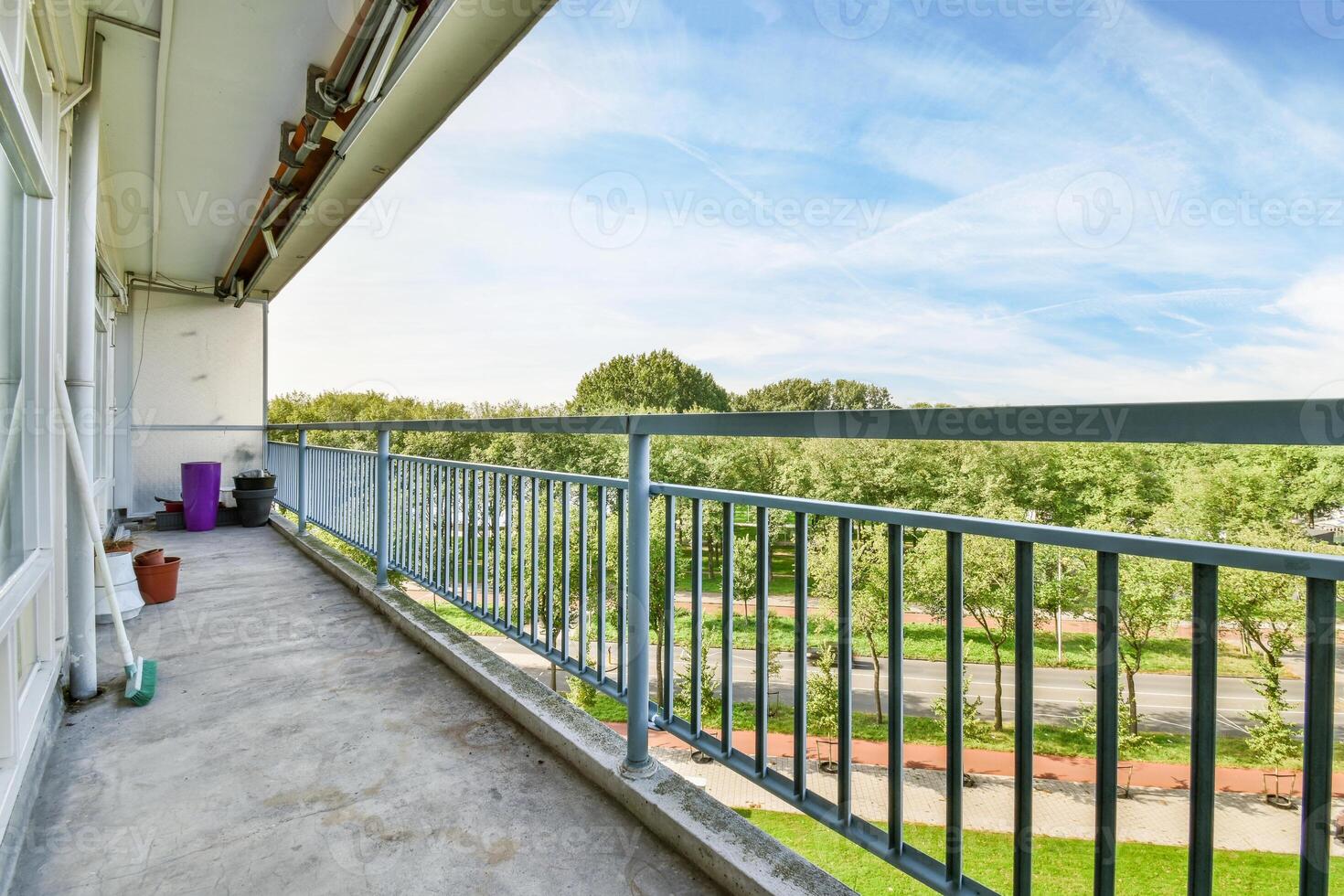 A balcony with a railing and a bench photo