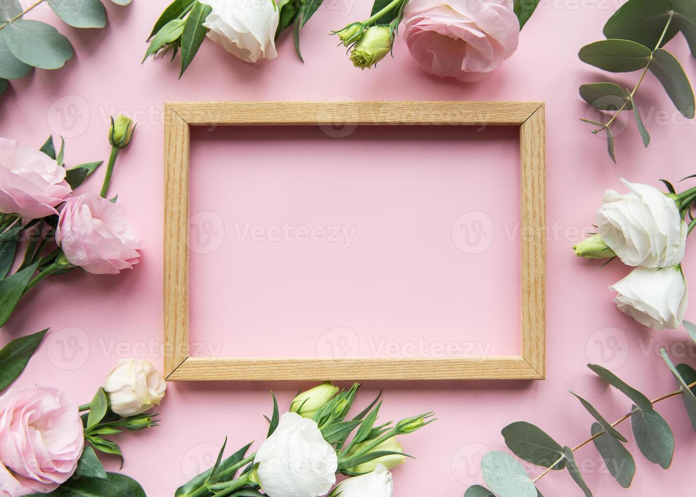 Elegant floral frame setup with pink background featuring fresh roses and greenery for decoration or display photo