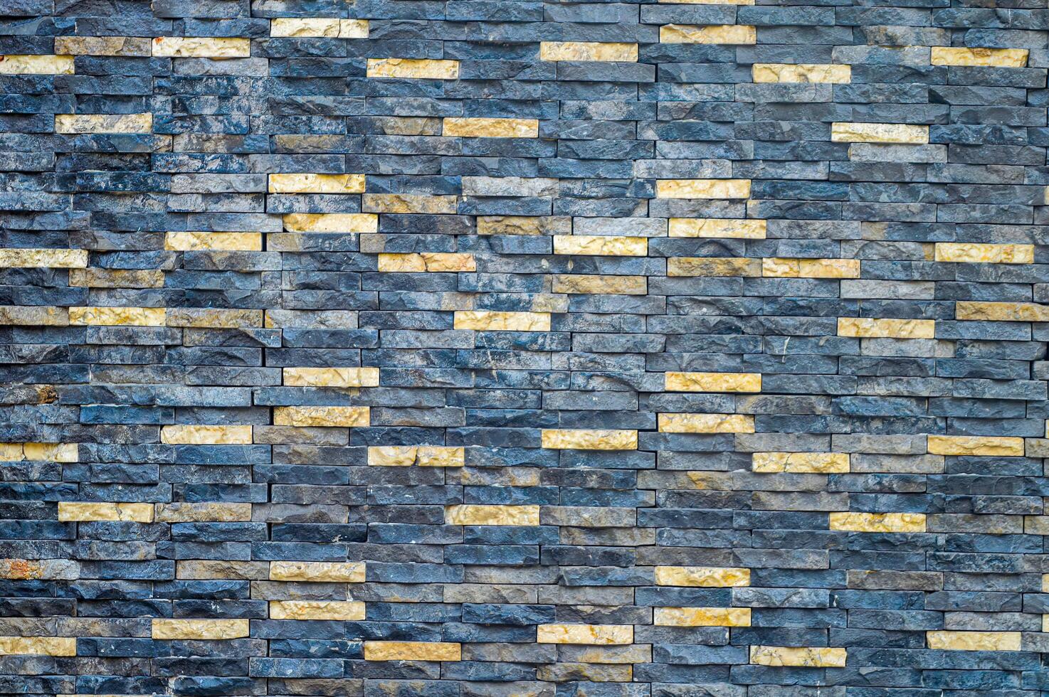 Textured stone wall with contrasting dark and light bricks, ideal for backgrounds and architectural designs photo