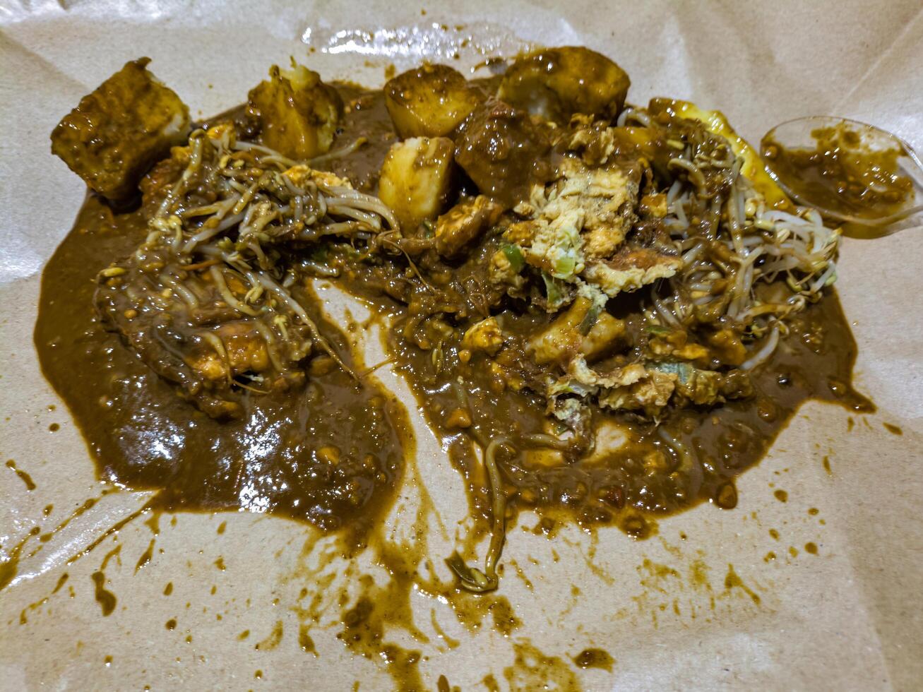 Traditional Indonesian Tahu Tek dish featuring fried tofu, bean sprouts, and boiled potatoes, all drizzled with a savory peanut sauce. Perfect for showcasing authentic Indonesian cuisine photo