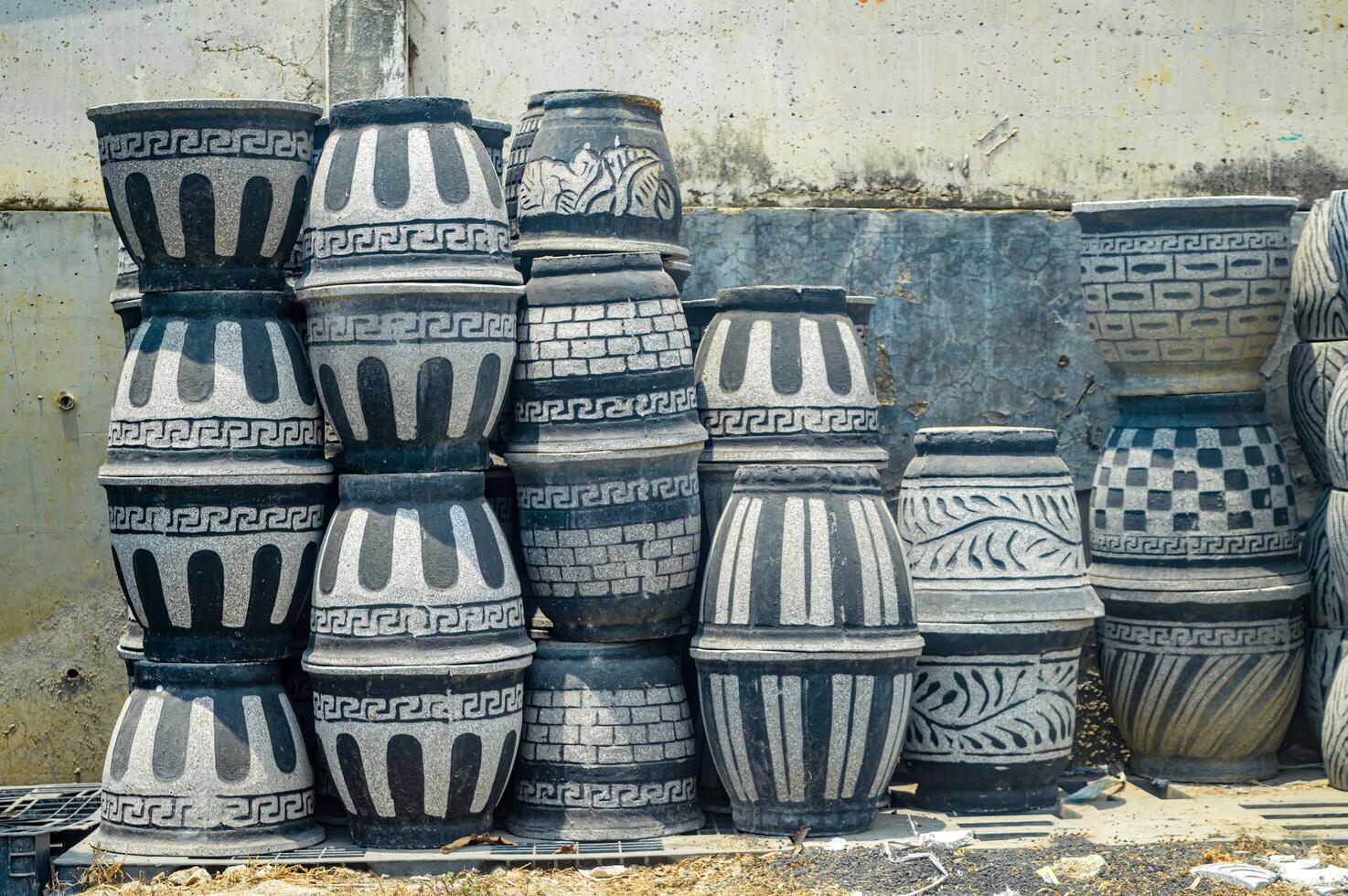 Stacked decorative concrete planters with ethnic patterns in an outdoor setting, showcasing artisanal garden decor photo
