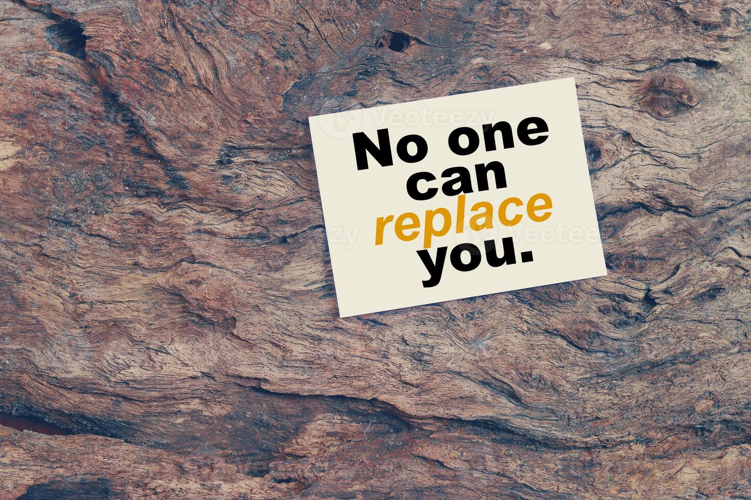 A piece of wood with a note on it that says no one can replace you photo