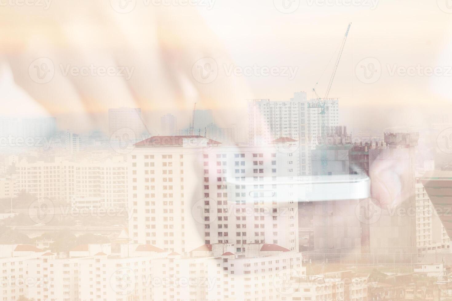 A person holding a cell phone in front of a city photo