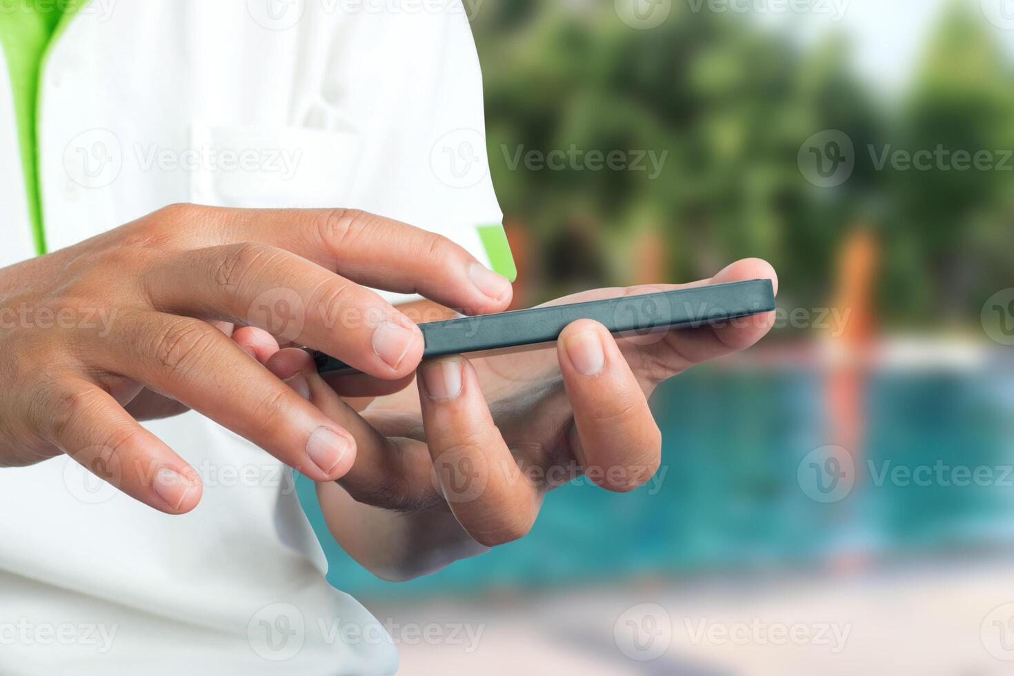 A man in a white shirt is holding a cell phone photo