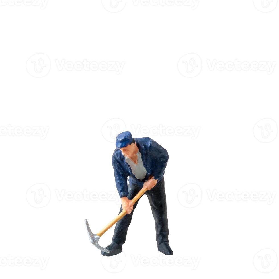 Miniature worker, wearing a blue jacket and cap, bends over while striking the ground isolate on white background with clipping path photo