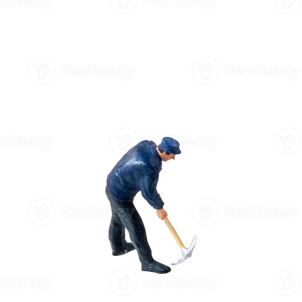 Miniature worker, wearing a blue jacket and cap, bends over while striking the ground isolate on white background with clipping path photo