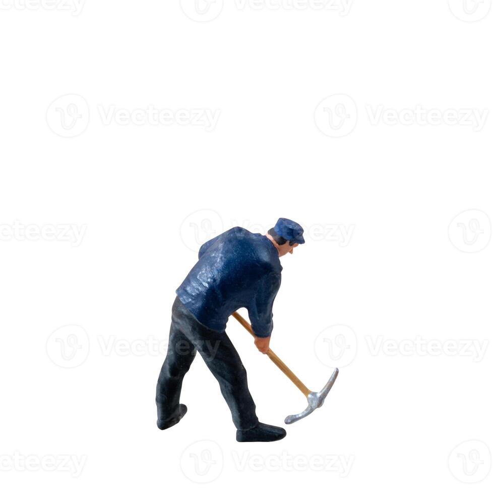 Miniature worker, wearing a blue jacket and cap, bends over while striking the ground isolate on white background with clipping path photo