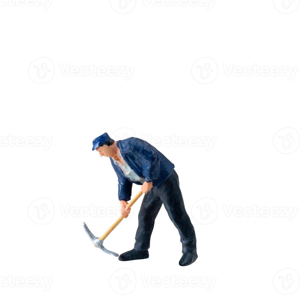 Miniature worker, wearing a blue jacket and cap, bends over while striking the ground isolate on white background with clipping path photo